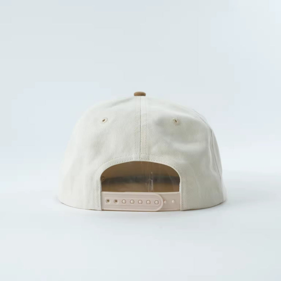 Lucky Beau 5-Panel Cap front, natural cotton crown with camel suede brim and gold Lucky Beau script